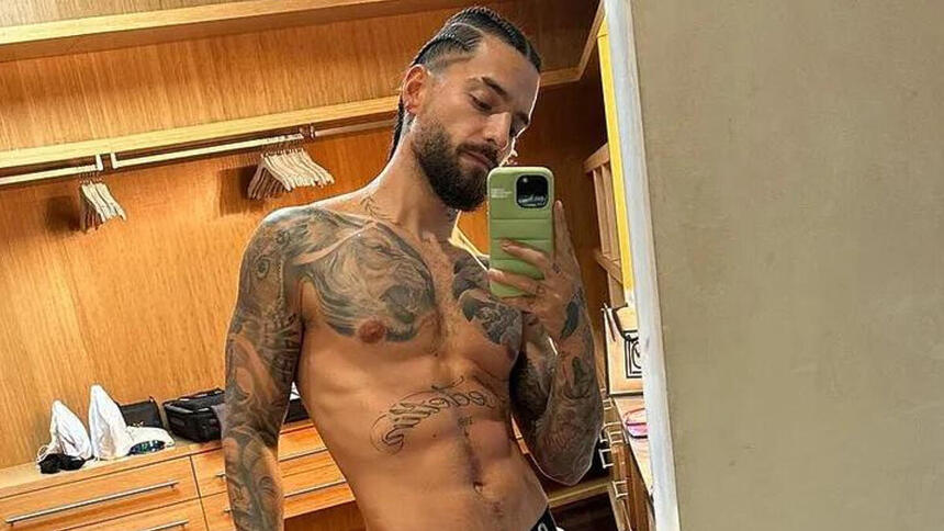 Maluma posando sem camisa e de cueca em frente a um espelho