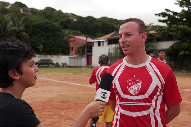 Repórter Júlia Sena no campo do Botafogo do Rio Grande do Norte, em trecho do Profissão Repórter