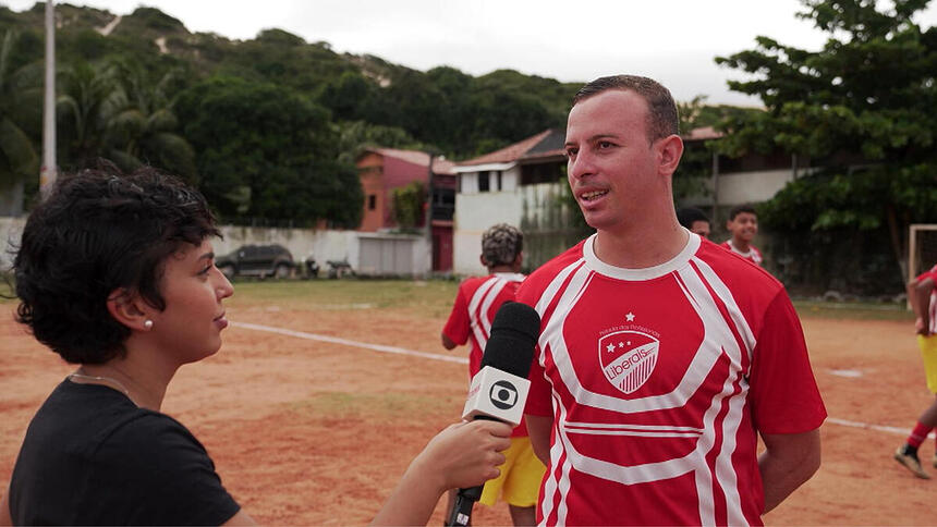 Repórter Júlia Sena no campo do Botafogo do Rio Grande do Norte, em trecho do Profissão Repórter