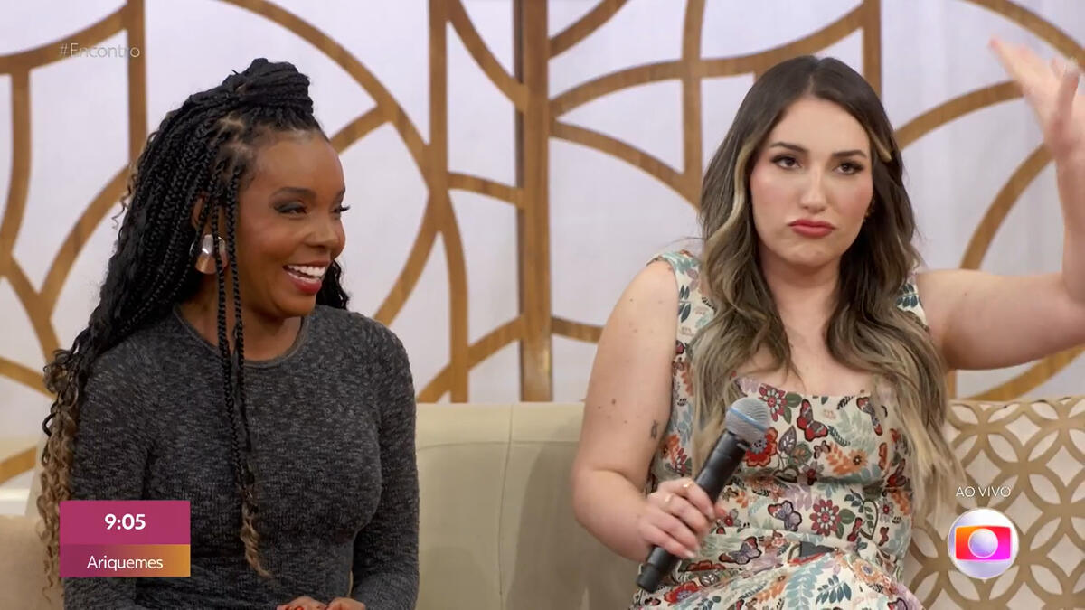Thelma sorrindo e Amanda levantando a mão no Encontro