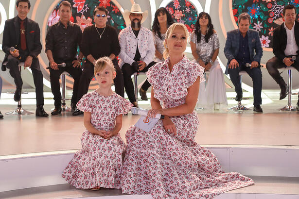 Manu, filha de Eliana sentada ao lado da apresentadora no palco do programa do SBT