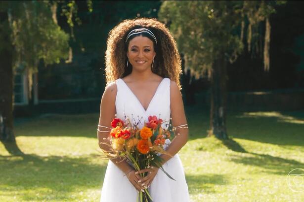 Sol, interpretada pela atriz Sheron Menezzes, de vestido de noiva e segurando um buquê de flores no último capítulo de Vai na Fé