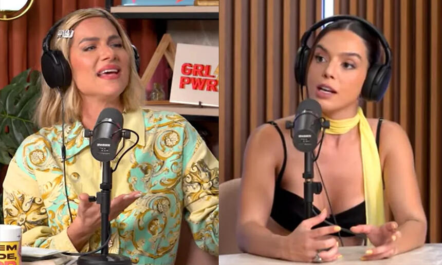 Giovanna Lancellotti de camisa preta e fone de ouvido, sentada durante entrevista com Giovanna Ewbank com camisa estampada em verde e amarela