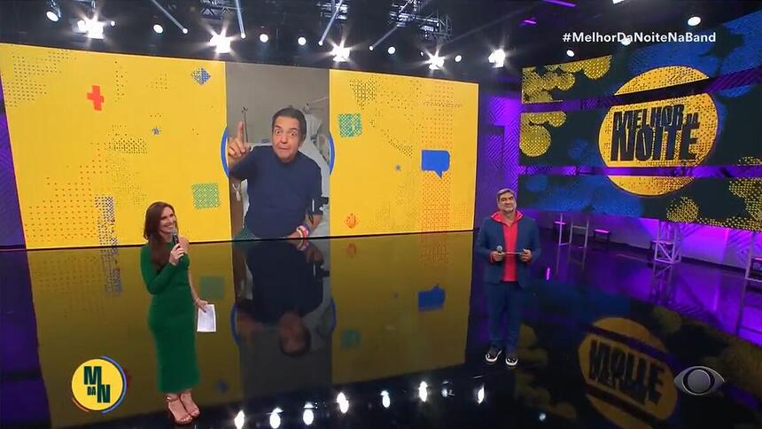 Faustão Silva aparece em vídeo no telão do Melhor da Noite enquanto Glenda Kozlowski e Zeca Camargo apresentam a atração