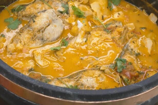 Moqueca de Peixe com banana-da-terra e lâminas de coco já pronta no prato do É de Casa