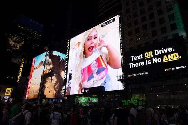 Suellen Carey no telão da Times Square pedindo vaga para Boninho no BBB