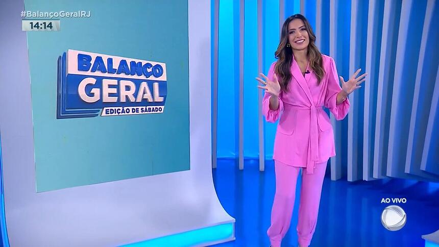 Paloma Poeta de conjunto rosa, sorridente apresentando o Balanço Geral RJ - Edição de sábado, ao vivo