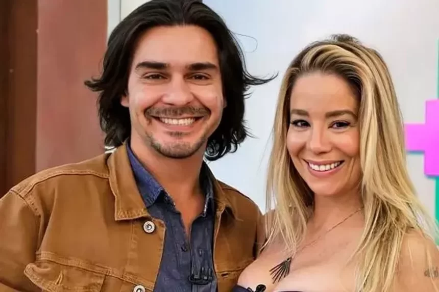 Danielle Winits e André Gonçalves sorrindo, sentados, durante gravação do Mais Você, em 2016