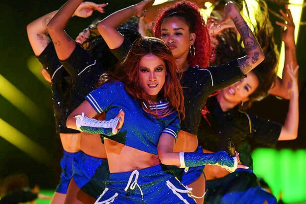 Anitta de look azul cercada de bailarinos durante final da Lia dos Campeões