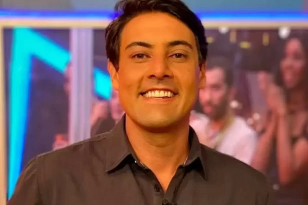 Bruno de Luca de camisa social preta, sorrindo, gravando um programa na TV Globo