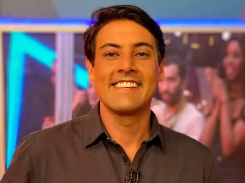 Bruno de Luca de camisa social preta, sorrindo, gravando um programa na TV Globo