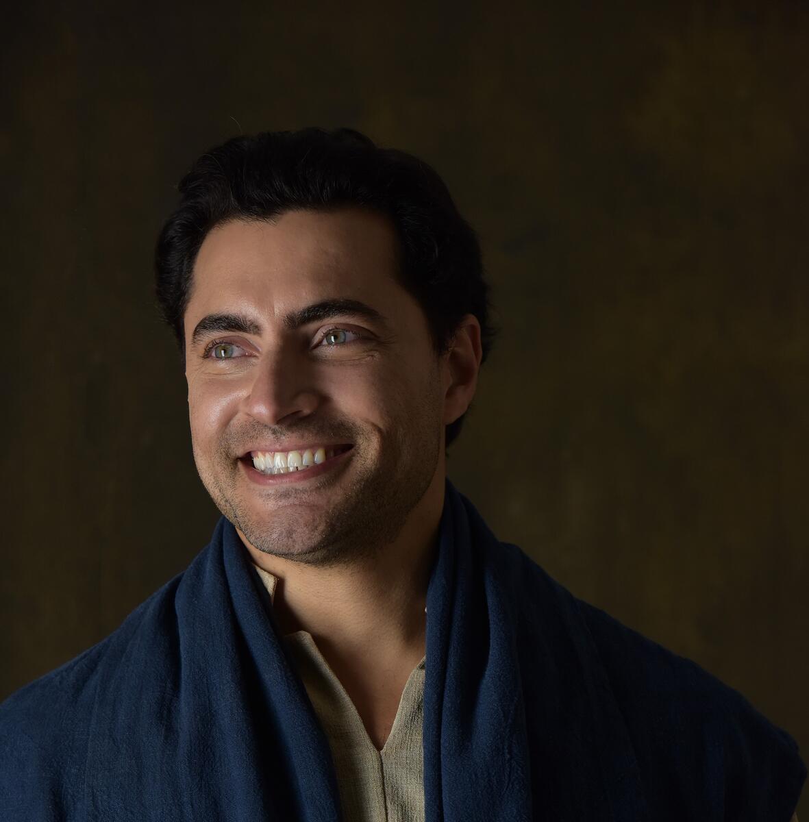 Carlo Porto sorrindo olhando para o lado direito em foto de divulgação de novela da Record
