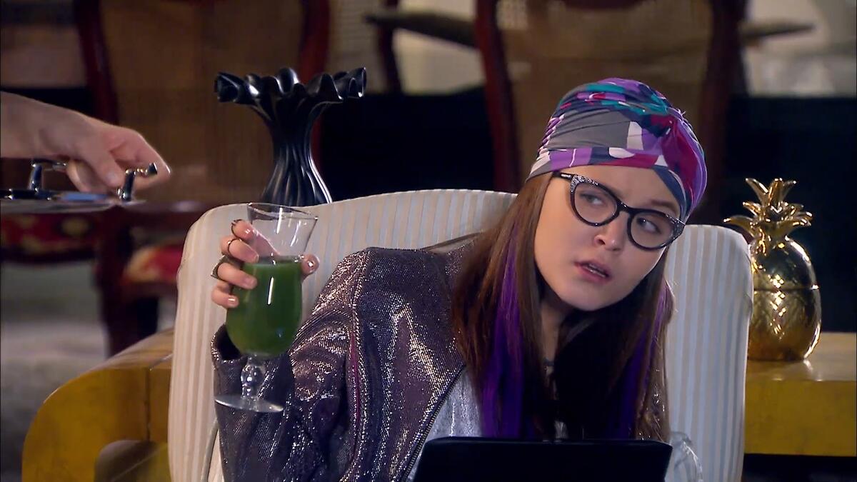 Isabela Larissa Manoela segura um copo de suco verde em cena de Cumplices de Um Resgate