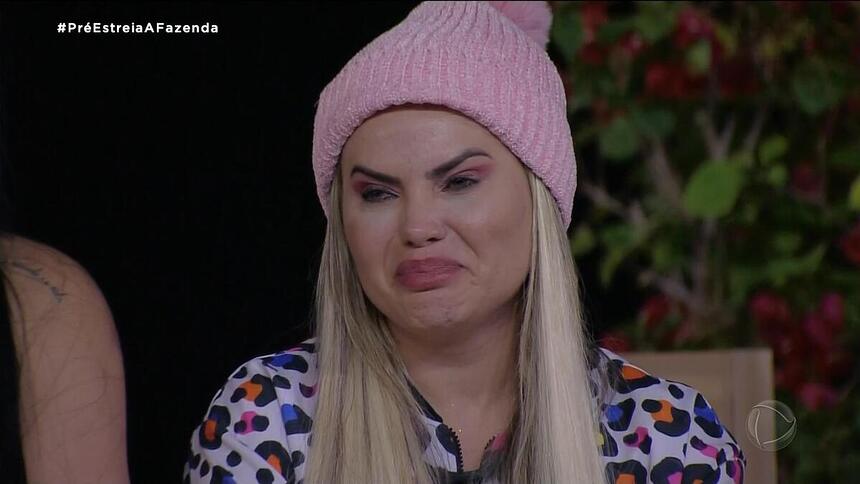 Kally Fonseca com toca rosa na cabeça chorando na primeira atividade de A Fazenda 15