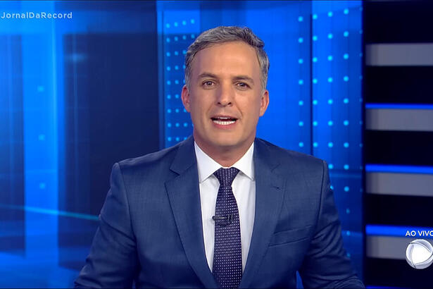 Leandro Stoliar sentado na bancada do Jornal da Record