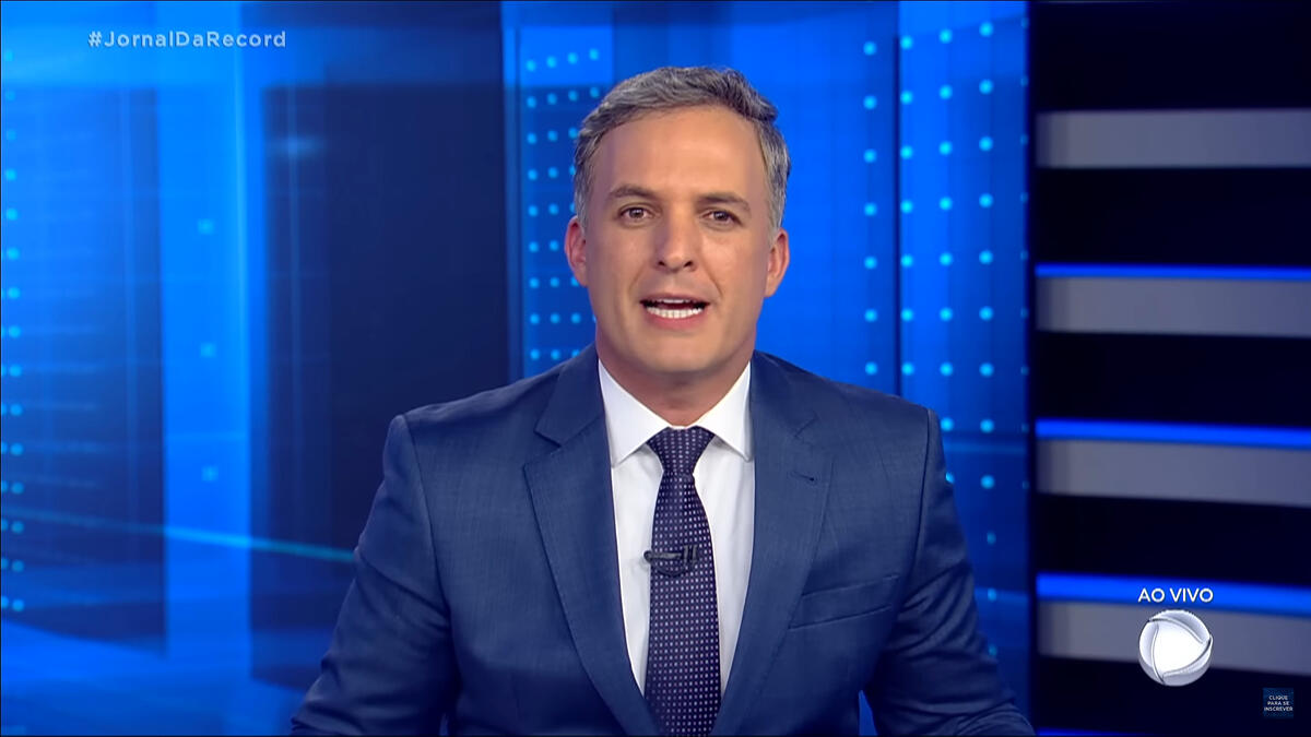 Leandro Stoliar sentado na bancada do Jornal da Record