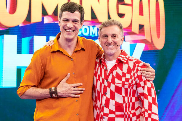 Mateus Solano e Luciano Huck em foto posada no cenário do Domingão