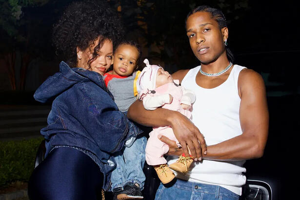 Rihanna e A$AP abraçados com o filho nos braços, encostados num carro, durante ensaio fotográfico