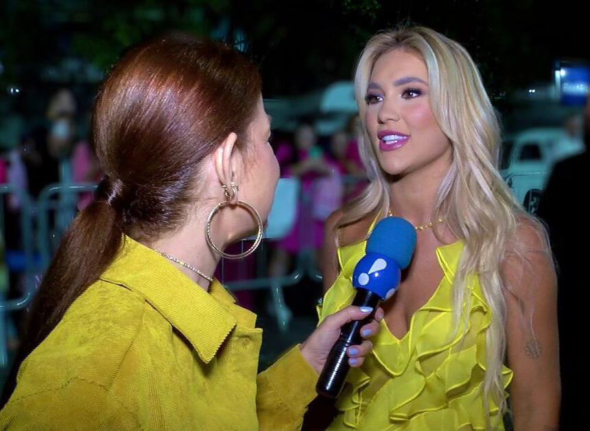 Virginia Fonseca veste um vestido amarelo e conversa com a repórter do TV Fama