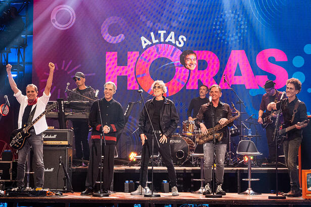 Integrantes do Titãs sentados no palco do Altas Horas