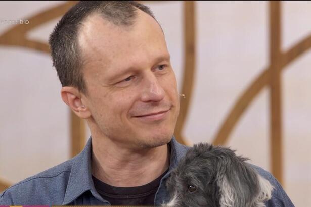 Alexandre Rossi chorando no Encontro e segurando seu cachorro no colo