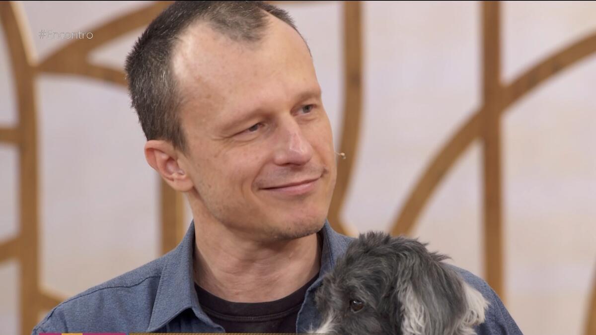 Alexandre Rossi chorando no Encontro e segurando seu cachorro no colo