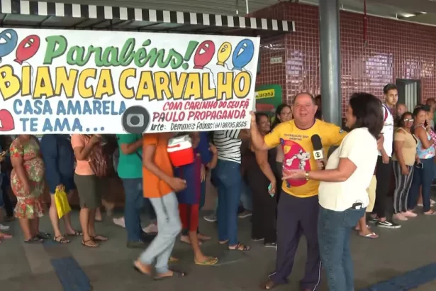 Paulo segura faixa de parabéns e felicita Bianka Carvalho ao vivo no Bom Dia PE