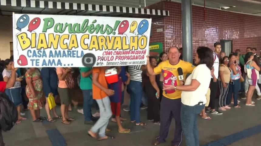 Paulo segura faixa de parabéns e felicita Bianka Carvalho ao vivo no Bom Dia PE