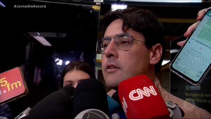 Bruno de Luca é cercado por vários microfones de diversas emissoras de TV na saída da delegacia