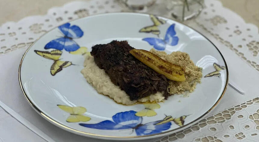 Carne braseada com pirão de leite no prato do É de Casa