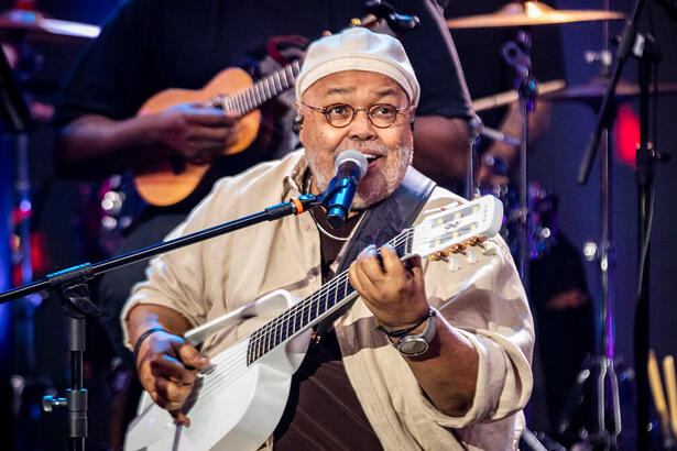 Jorge Aragão cantando e se apresentando no palco do Domingão