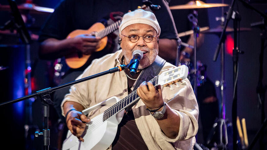 Jorge Aragão cantando e se apresentando no palco do Domingão