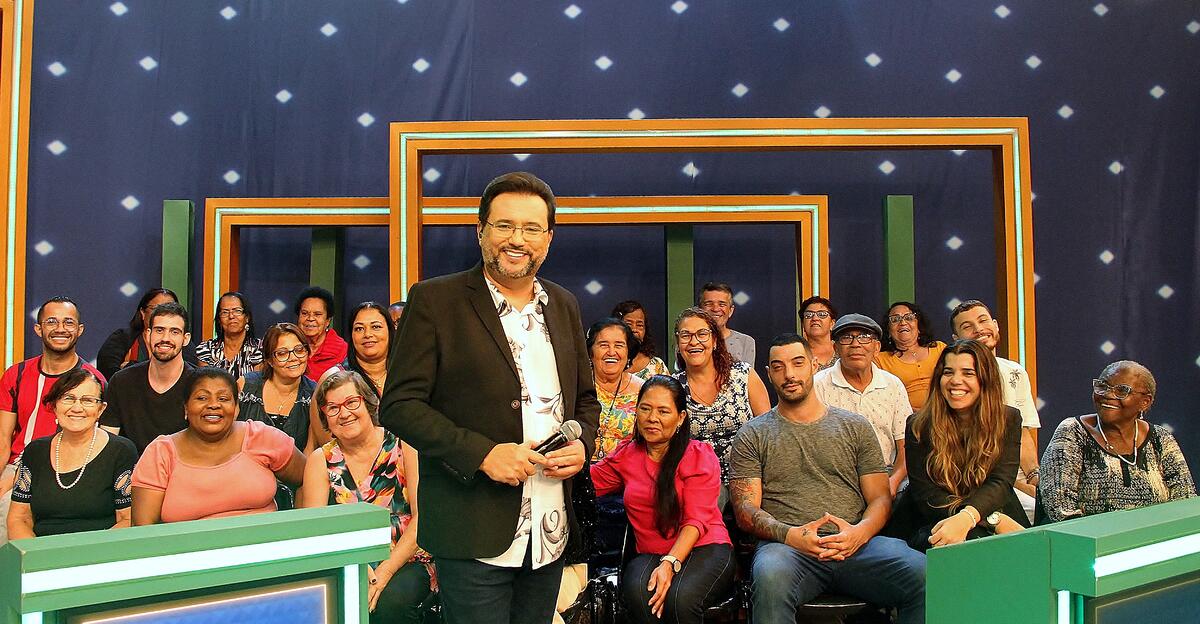 Geraldo Luís ao lado da plateia do seu programa, sorrindo