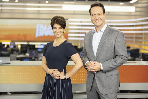 Mariana Godoy e Eduardo Ribeiro em frente a bancada do Fala Brasil