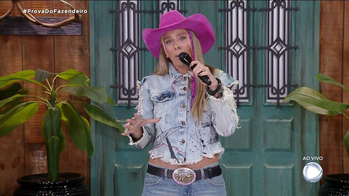 Adriane Galisteu de chapéu rosa alertando os peões sobre o caso de homofobia em A Fazenda