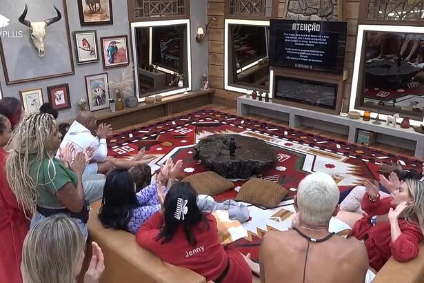 Peões reunidos na sala de frente para a TV