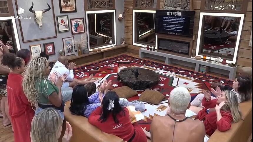 Peões reunidos na sala de frente para a TV