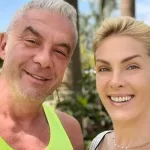 Ana Hickmann de camiseta branca, sorrindo, com cabelo preso, ao lado do marido