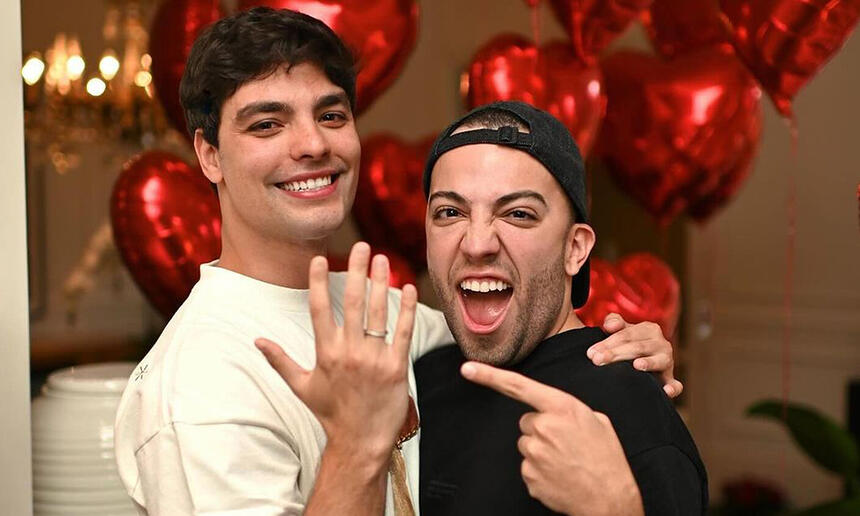 Lucas Rangel e Lucas Bley mostrando as alianças num quarto de hotel em São Paulo