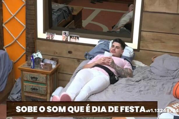 Lucas deitado na cama, segurando uma foto.