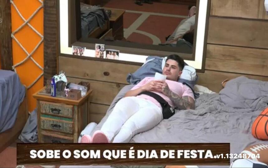 Lucas deitado na cama, segurando uma foto.