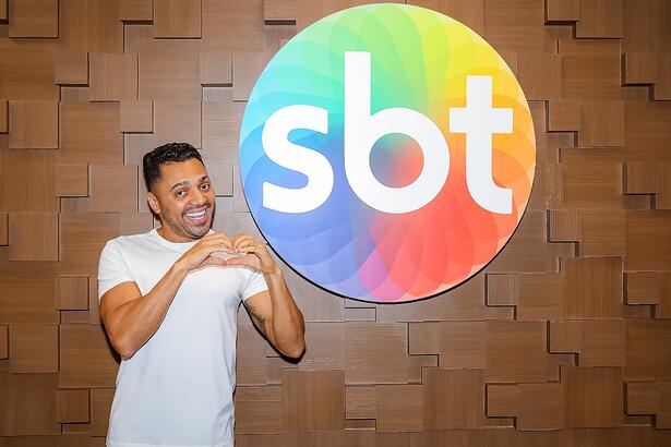 Tirulipa faz coração com a mão em frente ao logo do SBT