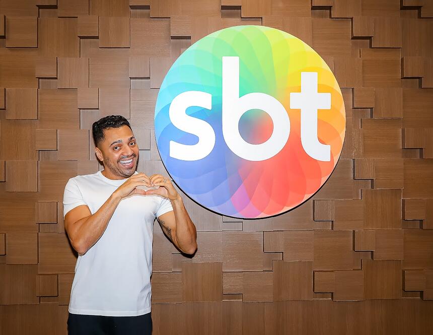 Tirulipa faz coração com a mão em frente ao logo do SBT