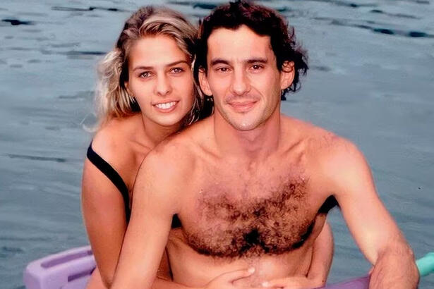 Adriane Galisteu de cabelo solto, sorrindo, de biquine preto, abraçada com Ayrton Senna