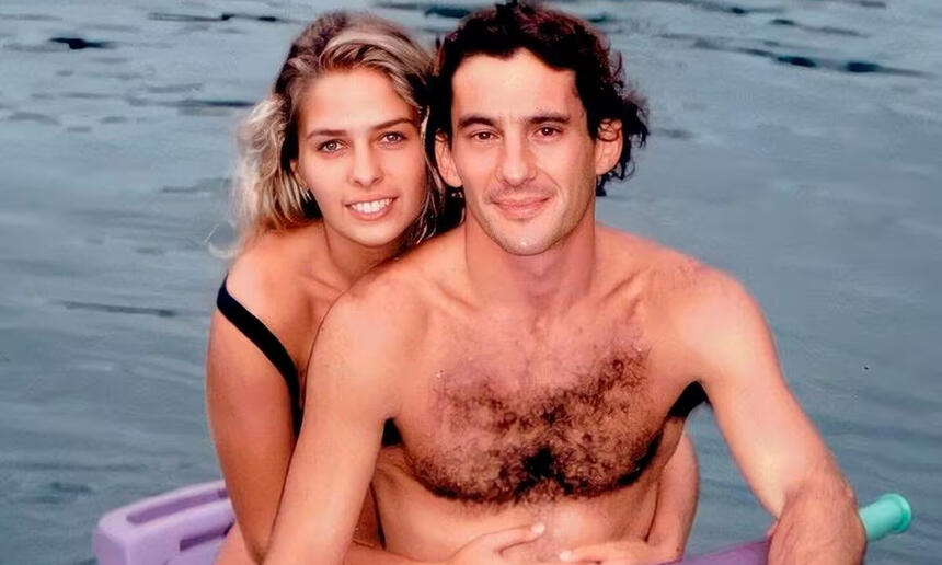 Adriane Galisteu de cabelo solto, sorrindo, de biquine preto, abraçada com Ayrton Senna