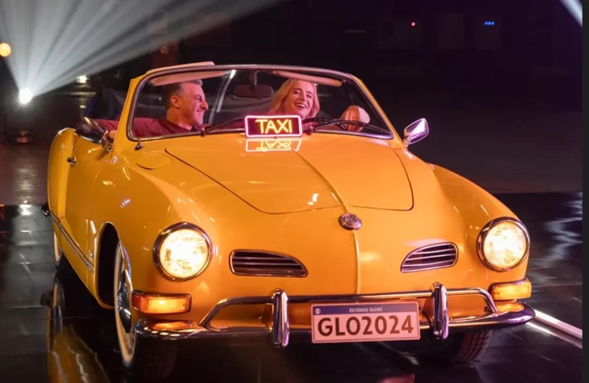 Angélica e Luciano Huck dentro de um taxi amarelo durante gravação de vinheta de final de ano