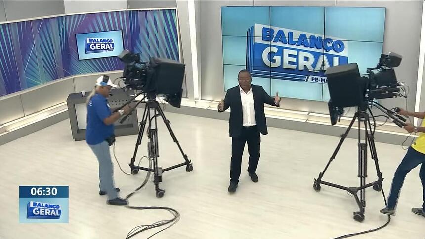 Evenilson Santana com os braços abertos no meio das câmeras do Balanço Geral Manhã PE