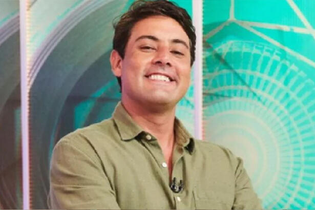 Bruno de Luca com camisa social verde, sorrindo, durante gravação de programa no Multishow