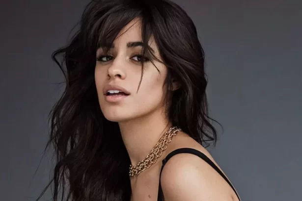 Camila Cabello de perfil, com semblante sexy, regata preta e colar de brilhantes durante ensaio fotográfico