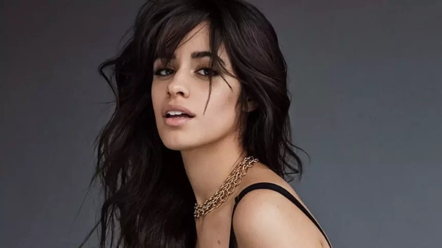 Camila Cabello de perfil, com semblante sexy, regata preta e colar de brilhantes durante ensaio fotográfico